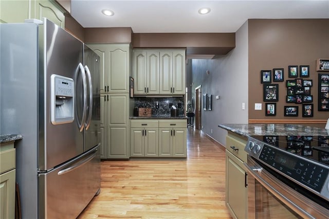 731 E 1100th Rd, Baldwin City, KS 66006 - kitchen featuring stainless steel appliances, light wood finished floors, backsplash, dark stone counters, and recessed lighting