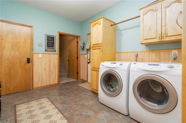 731 E 1100th Rd, Baldwin City, KS 66006 - laundry room with cabinet space, washing machine and clothes dryer, wainscoting, dark stone finish floors, and wooden walls