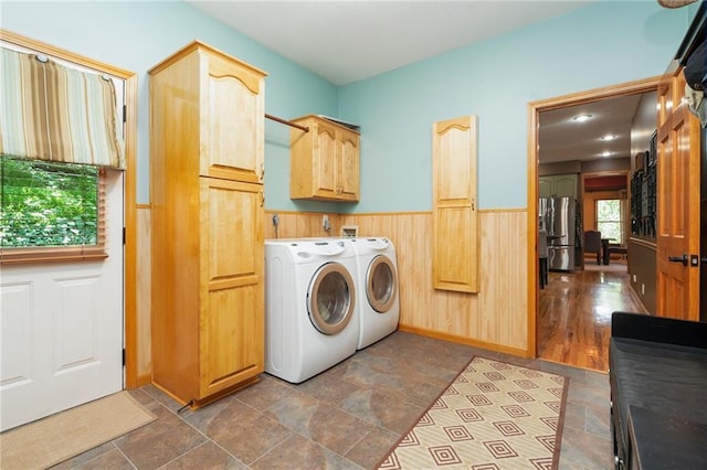 731 E 1100th Rd, Baldwin City, KS 66006 - laundry room featuring washer and dryer, cabinet space, dark stone finish floors, wainscoting, and wooden walls