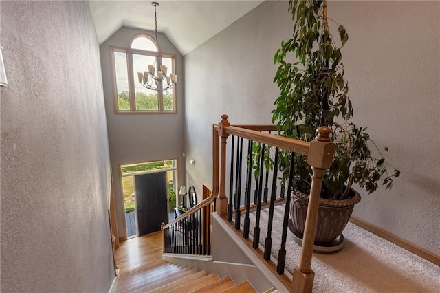 731 E 1100th Rd, Baldwin City, KS 66006 - staircase with a textured wall, a chandelier, and vaulted ceiling