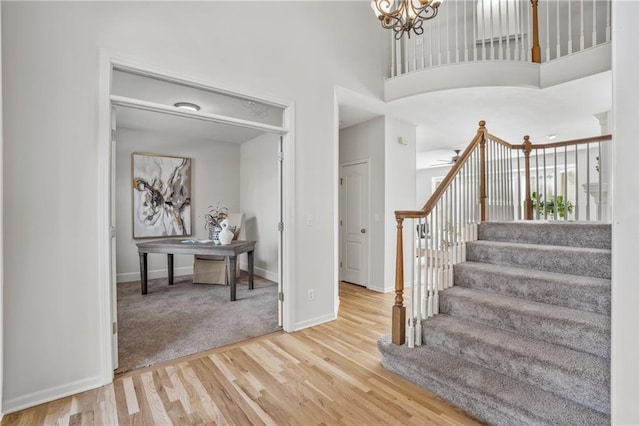 5701 W 146th St, Overland Park, KS 66223 - staircase with wood finished floors, a high ceiling, and a chandelier