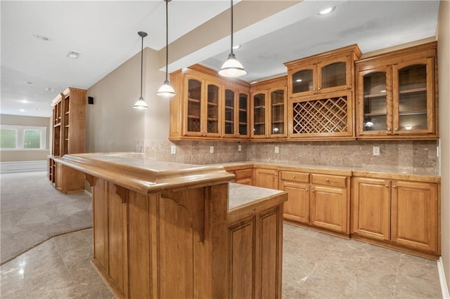 5701 W 146th St, Overland Park, KS 66223 - kitchen with a breakfast bar area, brown cabinetry, a peninsula, pendant lighting, and glass insert cabinets