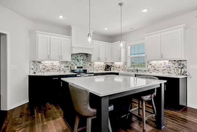 24322 W 58th Cir, Shawnee, KS 66226 - kitchen with light countertops, a breakfast bar, stainless steel range with electric stovetop, a kitchen island, and dark wood-style flooring
