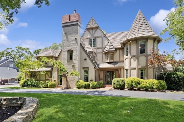 8320 Maplewood Ln, Lenexa, KS 66215 - english style home featuring stucco siding, a chimney, and a front lawn