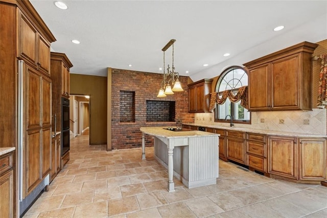 8320 Maplewood Ln, Lenexa, KS 66215 - kitchen featuring a brick fireplace, brown cabinets, tasteful backsplash, a breakfast bar, and pendant lighting