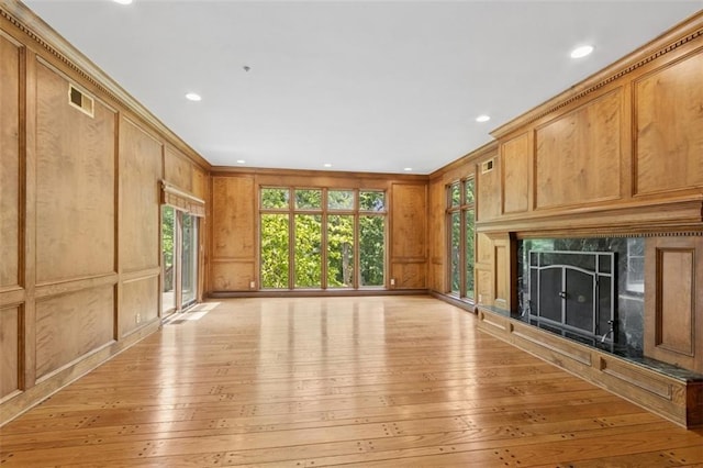 8320 Maplewood Ln, Lenexa, KS 66215 - unfurnished living room featuring light wood-style flooring, a premium fireplace, a decorative wall, recessed lighting, and crown molding