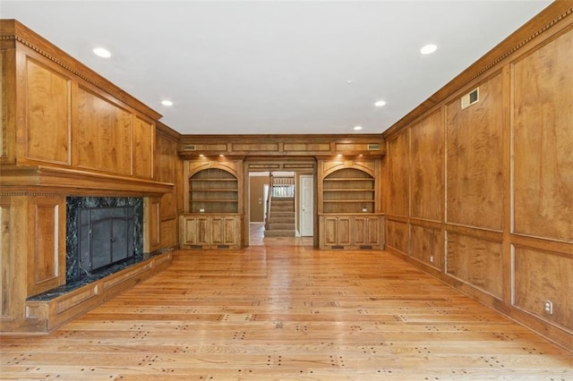 8320 Maplewood Ln, Lenexa, KS 66215 - unfurnished living room featuring a high end fireplace, light wood-style flooring, stairs, recessed lighting, and crown molding