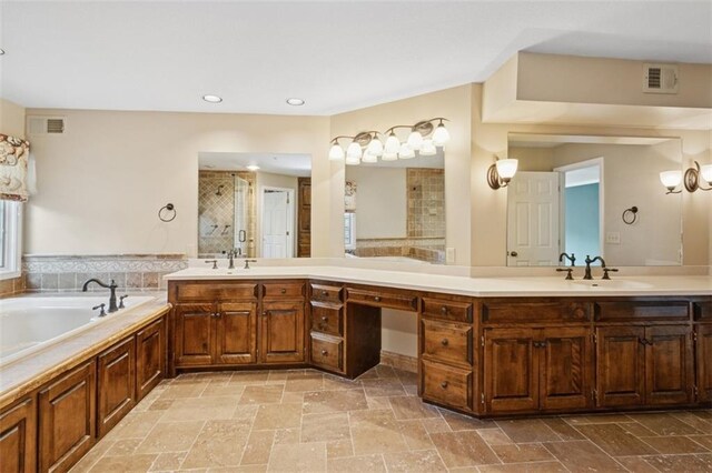8320 Maplewood Ln, Lenexa, KS 66215 - full bath featuring double vanity, tiled shower, stone tile floors, a bath, and recessed lighting