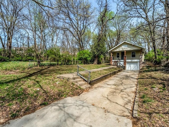 3928 E 58th St, Kansas City, MO 64132 - view of yard with a porch, driveway, an attached garage, and stairs