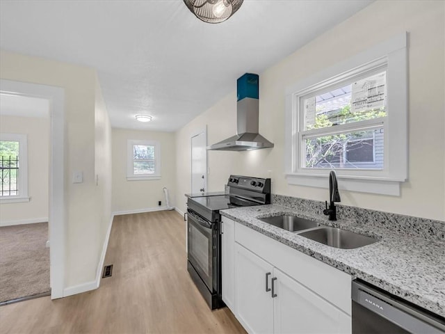 3928 E 58th St, Kansas City, MO 64132 - kitchen with black electric range oven, wall chimney range hood, dishwasher, light wood finished floors, and white cabinets