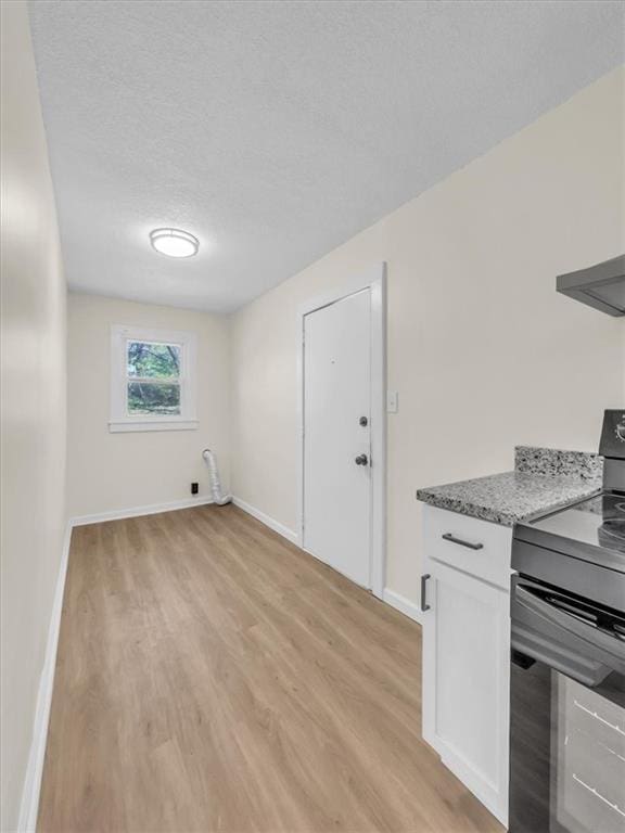 3928 E 58th St, Kansas City, MO 64132 - washroom with light wood finished floors and a textured ceiling