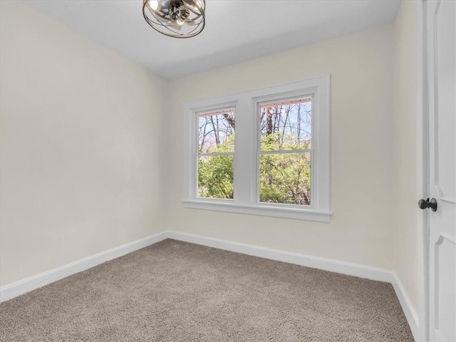 3928 E 58th St, Kansas City, MO 64132 - carpeted spare room featuring baseboards and a chandelier