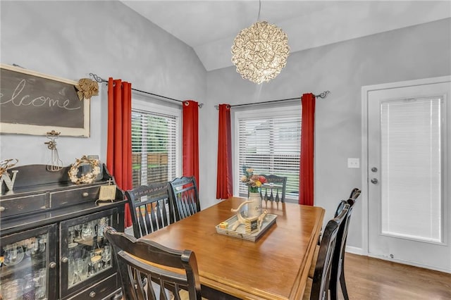 23968 Eagle Ct, Paola, KS 66071 - dining room with vaulted ceiling, a chandelier, and wood finished floors