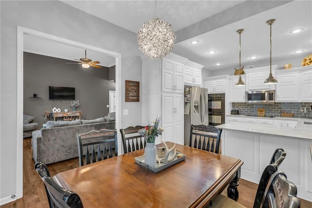 23968 Eagle Ct, Paola, KS 66071 - dining space with ceiling fan, wood finished floors, a chandelier, and recessed lighting