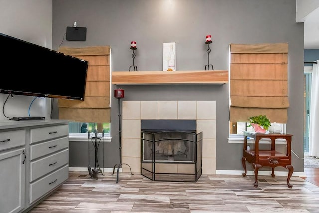 1229 Starbrooke Dr, Louisburg, KS 66053 - living room with light wood-type flooring, a tile fireplace, and healthy amount of natural light