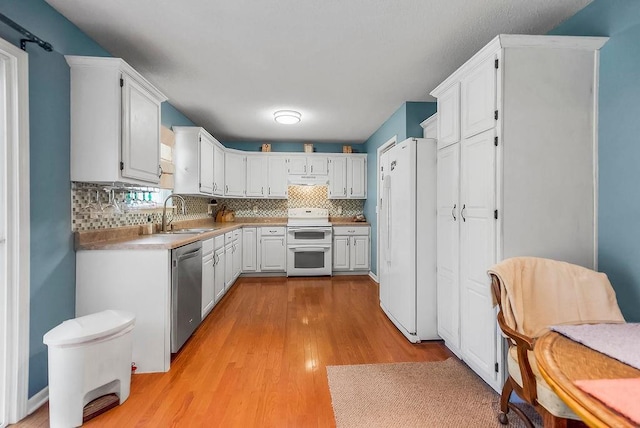 1229 Starbrooke Dr, Louisburg, KS 66053 - kitchen featuring range with two ovens, freestanding refrigerator, stainless steel dishwasher, light wood finished floors, and backsplash