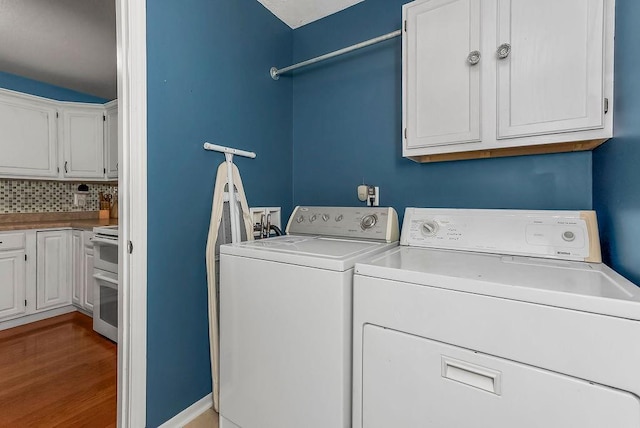 1229 Starbrooke Dr, Louisburg, KS 66053 - laundry room featuring washer and dryer, cabinet space, and wood finished floors
