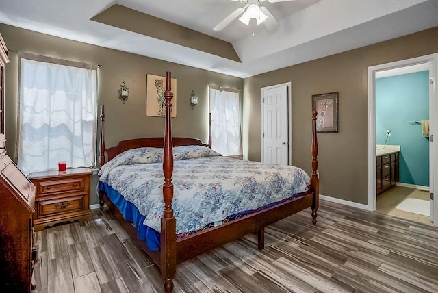 1229 Starbrooke Dr, Louisburg, KS 66053 - bedroom featuring a tray ceiling, wood finished floors, ensuite bathroom, and ceiling fan