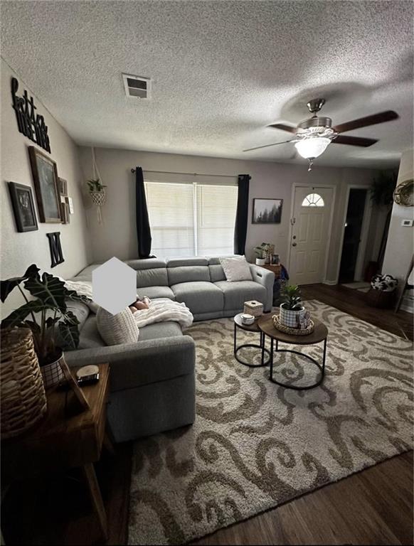 1529 E 120th St, Olathe, KS 66061 - living area featuring wood finished floors, a ceiling fan, and a textured ceiling