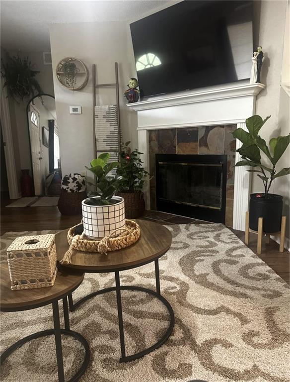 1529 E 120th St, Olathe, KS 66061 - living room featuring a tiled fireplace and wood finished floors