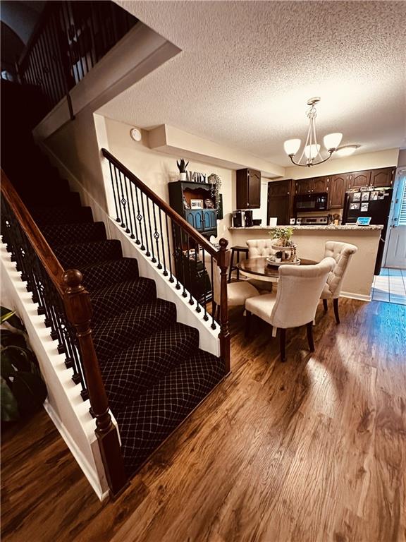 1529 E 120th St, Olathe, KS 66061 - stairway featuring a chandelier, wood finished floors, and a textured ceiling