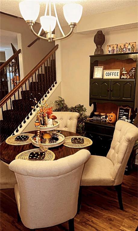 1529 E 120th St, Olathe, KS 66061 - dining room featuring a chandelier, stairs, a textured ceiling, and wood finished floors