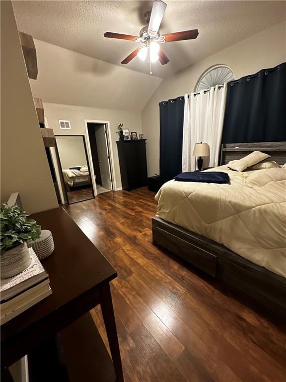 1529 E 120th St, Olathe, KS 66061 - bedroom with vaulted ceiling, wood finished floors, a textured ceiling, and a ceiling fan