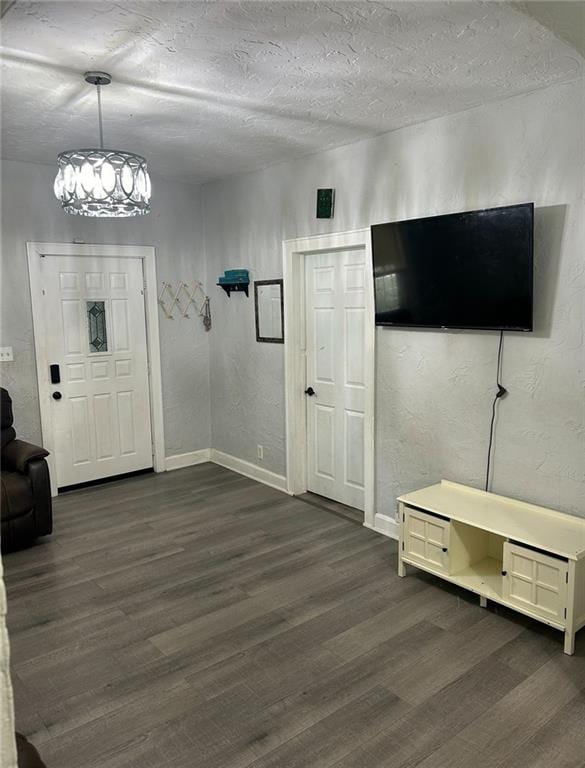 4123 E 6th St, Kansas City, MO 64124 - entryway featuring dark wood-type flooring, a chandelier, and a textured ceiling
