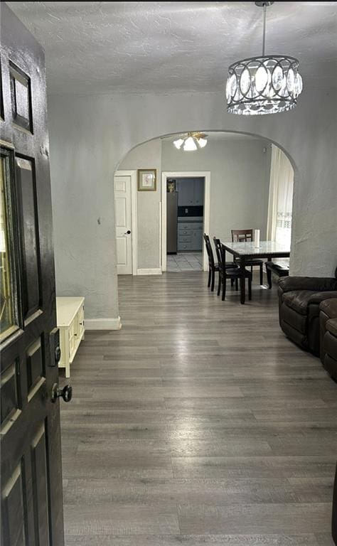 4123 E 6th St, Kansas City, MO 64124 - dining area featuring arched walkways, a chandelier, dark wood finished floors, and a textured ceiling
