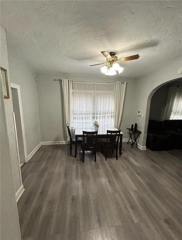 4123 E 6th St, Kansas City, MO 64124 - dining space featuring arched walkways, a textured ceiling, dark wood finished floors, and ceiling fan