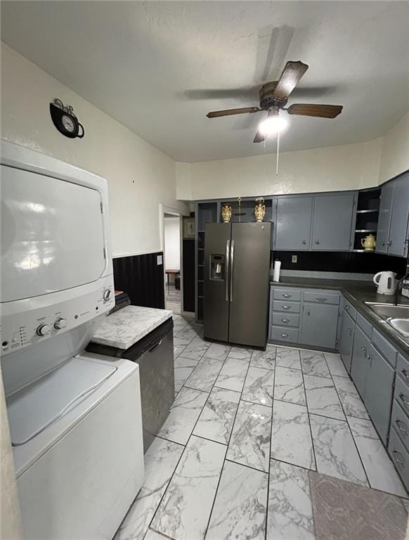 4123 E 6th St, Kansas City, MO 64124 - kitchen featuring stacked washing machine and dryer, open shelves, gray cabinetry, light marble finish flooring, and stainless steel fridge