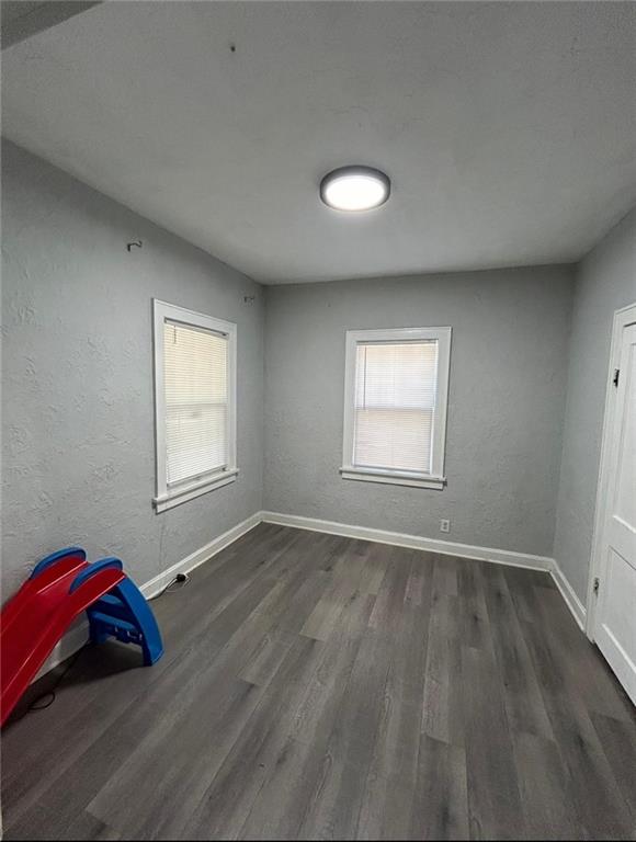 4123 E 6th St, Kansas City, MO 64124 - unfurnished bedroom with multiple windows and wood finished floors