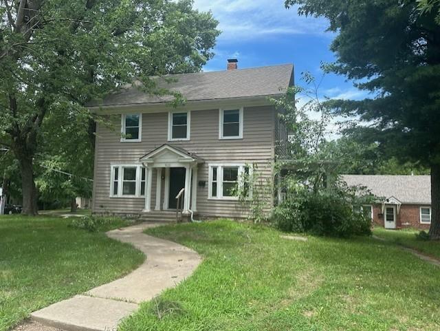 9600 E 16th St, Independence, MO 64052 - colonial-style house featuring a front yard and a chimney
