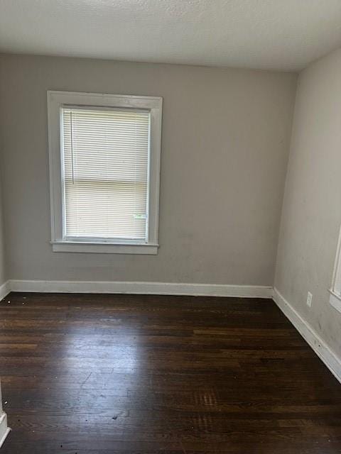 9600 E 16th St, Independence, MO 64052 - empty room featuring healthy amount of natural light and dark wood-style floors