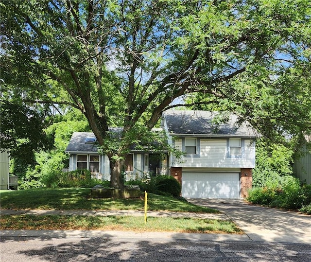 9318 Greenway Ln, Lenexa, KS 66215 - split level home with a garage, concrete driveway, and brick siding