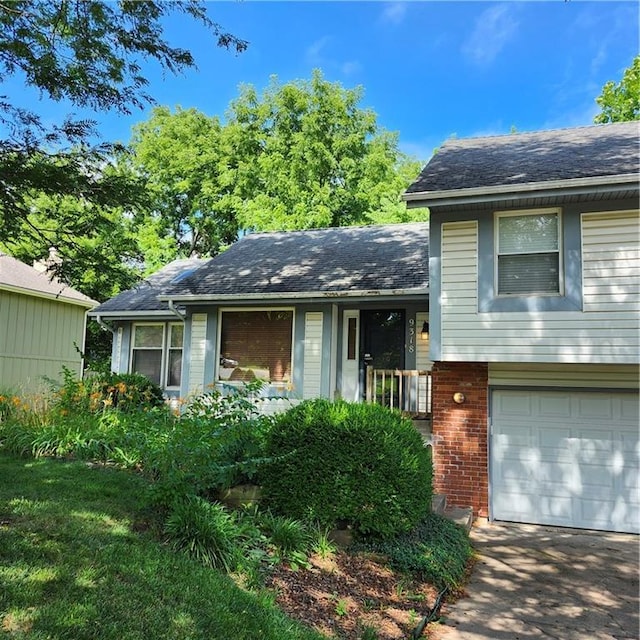 9318 Greenway Ln, Lenexa, KS 66215 - tri-level home featuring an attached garage, brick siding, and a shingled roof