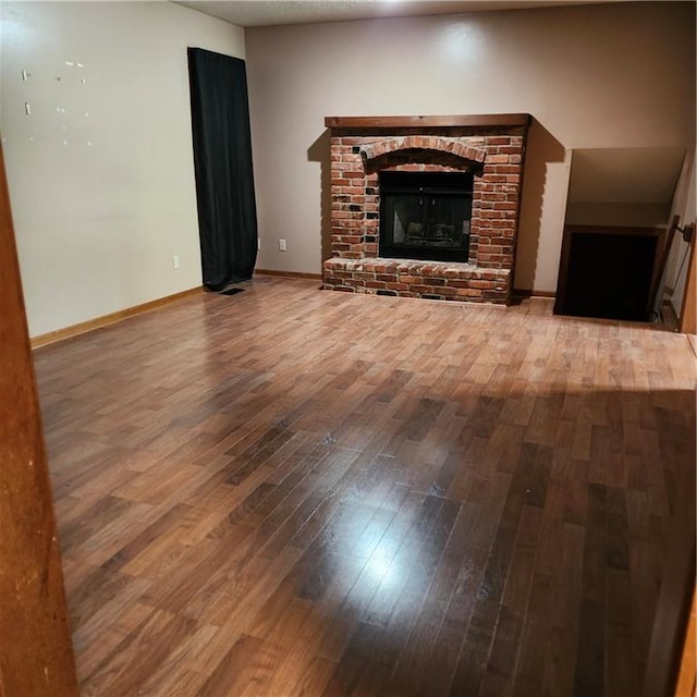9318 Greenway Ln, Lenexa, KS 66215 - unfurnished living room with wood-type flooring and a fireplace