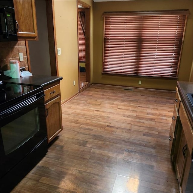 9318 Greenway Ln, Lenexa, KS 66215 - kitchen featuring black appliances, dark countertops, light wood-style floors, and decorative backsplash