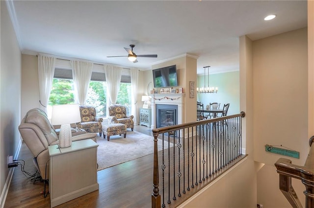 11514 W 143rd Ter, Olathe, KS 66062 - living room featuring crown molding, wood finished floors, ceiling fan, a glass covered fireplace, and recessed lighting