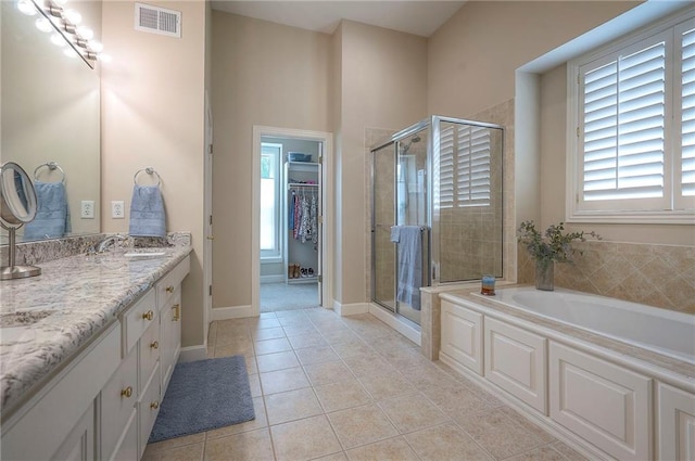 11514 W 143rd Ter, Olathe, KS 66062 - full bathroom with vanity, a stall shower, a bath, tile patterned flooring, and a walk in closet