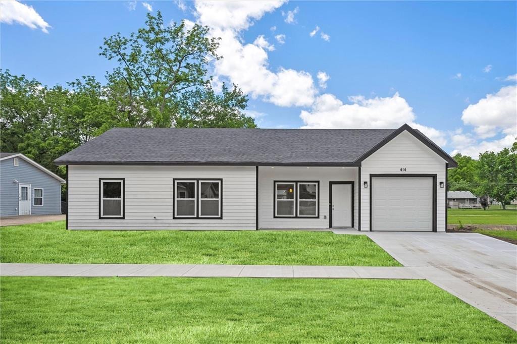 525 N Cedar St, Ottawa, KS 66067 - view of front of property featuring a garage, a front yard, driveway, and a shingled roof