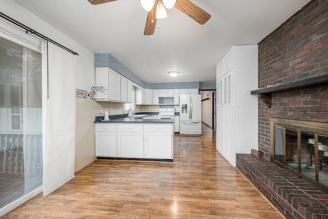 20723 Kissinger Rd, Tonganoxie, KS 66086 - kitchen featuring white fridge with ice dispenser, dark countertops, ceiling fan, white cabinets, and a peninsula