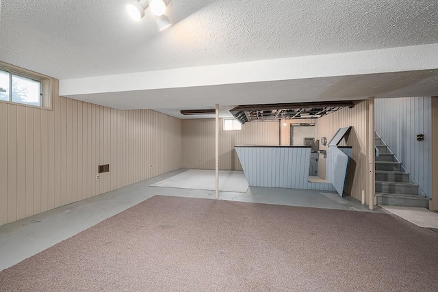 20723 Kissinger Rd, Tonganoxie, KS 66086 - basement featuring stairs, a textured ceiling, carpet flooring, and wooden walls