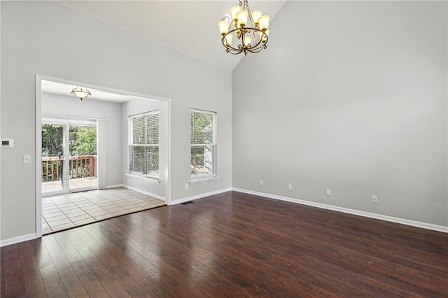 701 Redbud Dr, Paola, KS 66071 - spare room with a chandelier, wood-type flooring, and high vaulted ceiling