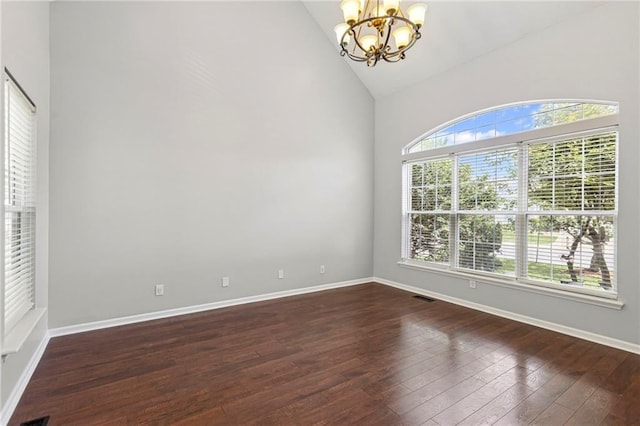 701 Redbud Dr, Paola, KS 66071 - empty room featuring a chandelier, dark wood-style flooring, and high vaulted ceiling