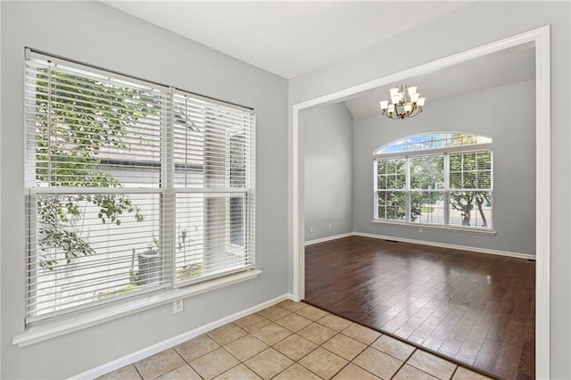 701 Redbud Dr, Paola, KS 66071 - tiled spare room with a chandelier and baseboards