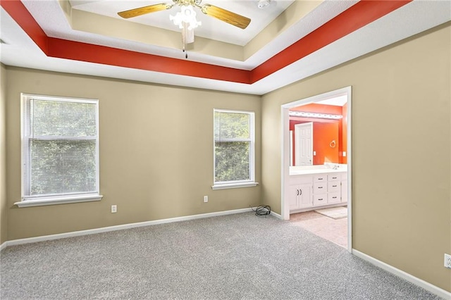 701 Redbud Dr, Paola, KS 66071 - carpeted spare room with a tray ceiling and ceiling fan