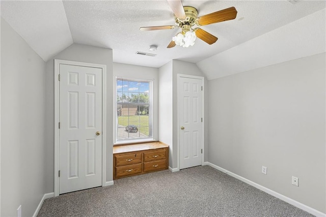 701 Redbud Dr, Paola, KS 66071 - unfurnished bedroom featuring vaulted ceiling, light carpet, a ceiling fan, and a textured ceiling