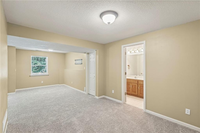 701 Redbud Dr, Paola, KS 66071 - unfurnished bedroom with a textured ceiling, light carpet, and ensuite bath