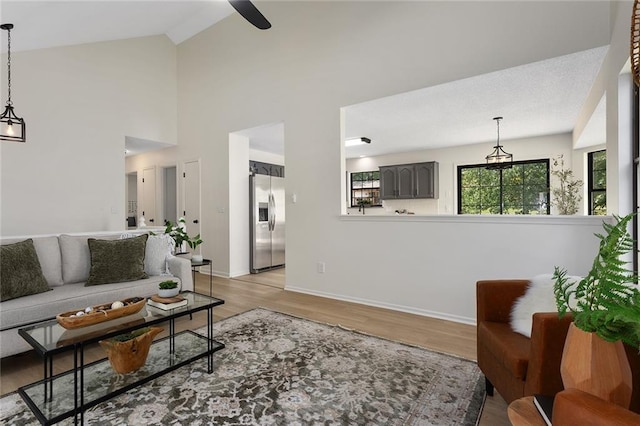 404 SE Bristol Dr, Lees Summit, MO 64063 - living area featuring wood finished floors, vaulted ceiling, and a ceiling fan